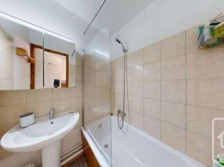 This bathroom features a clean and functional design with a bathtub and shower combination, perfect for relaxing after a long day.
