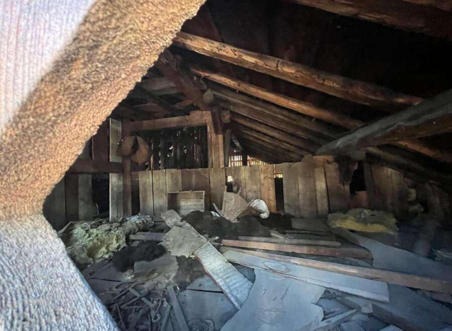 Explore the potential of this unique attic space, featuring rustic wooden beams and ample room for creative renovation.