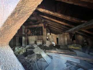 Explore the potential of this unique attic space, featuring rustic wooden beams and ample room for creative renovation.