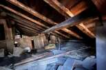 Explore the potential of this spacious attic, featuring robust wooden beams and ample room for storage or conversion.