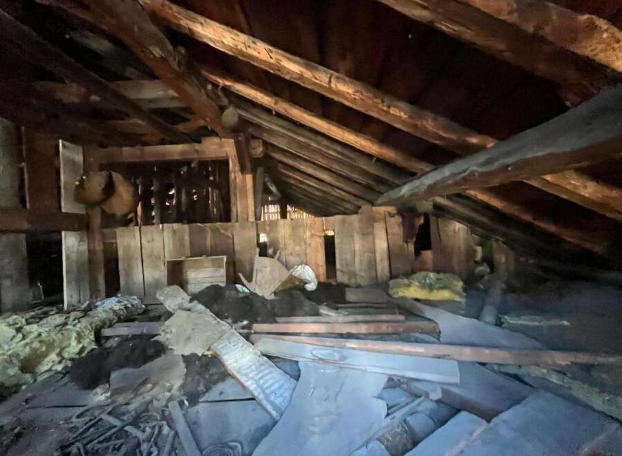 Explore the potential of this unique attic space, featuring rustic exposed wooden beams and ample room for creative renovation.