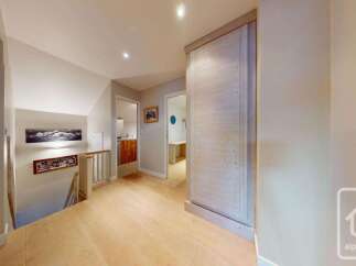Discover this charming hallway featuring a wooden staircase leading to the upper level.