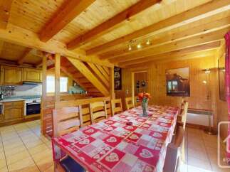 Experience cozy living in this charming wooden chalet, featuring a spacious dining area perfect for family gatherings.
