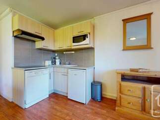 This charming studio apartment features a compact yet functional kitchenette equipped with a microwave, dishwasher, and refrigerator, perfect for preparing simple meals.