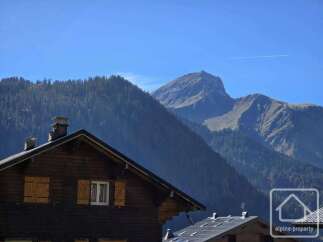 Experience alpine living in this charming wooden chalet, nestled against a backdrop of majestic mountains.