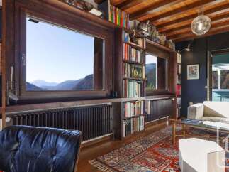Experience breathtaking mountain views from this stunning living room, featuring expansive windows that frame the picturesque landscape.