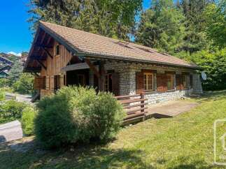 Nestled amidst lush greenery, this charming stone and wood chalet offers a serene mountain retreat.