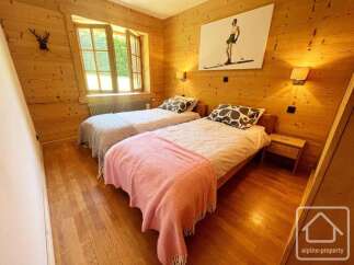Experience cozy mountain living in this charming bedroom featuring two comfortable beds, perfect for a relaxing getaway.