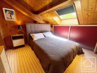 Discover this charming attic bedroom featuring a comfortable double bed with a plush headboard, perfect for a cozy retreat.