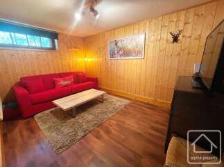 Cozy living room featuring a vibrant red sofa, a rustic wooden coffee table, and a plush rug, perfect for relaxation.