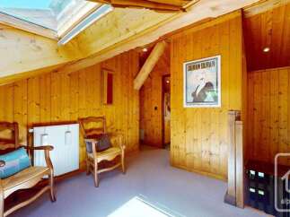 Experience cozy living in this charming attic room, featuring warm wooden paneling and a large skylight that floods the space with natural light.