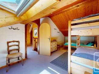 Discover this charming attic bedroom featuring a cozy bunk bed setup, perfect for families or groups.