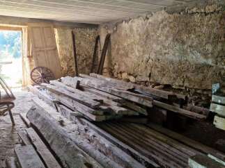 Discover the rustic charm of this property's interior, featuring exposed stone walls and a wooden beamed ceiling, hinting at its historical character.