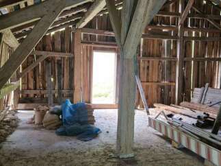 Explore the rustic charm of this barn, featuring robust wooden beams and a traditional timber frame construction.