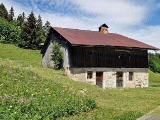 Discover this charming rustic barn nestled in a picturesque alpine meadow, perfect for renovation or as a unique storage space.