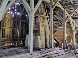 Explore the rustic charm of this traditional wooden barn, featuring robust timber framing and a corrugated metal roof.