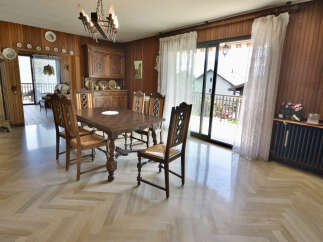 This charming dining room features a large wooden table with four chairs, perfect for family meals.