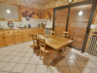 This charming kitchen features warm wooden cabinetry and a spacious dining area perfect for family meals.