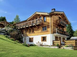 Experience alpine living in this stunning wooden chalet, featuring multiple balconies with breathtaking mountain views.