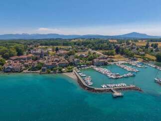 Discover this charming lakeside village featuring a picturesque harbor filled with sailboats and motorboats.