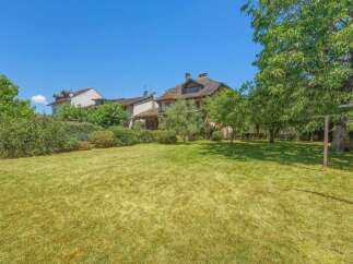 Enjoy the spacious green lawn of this beautiful property, perfect for outdoor activities and relaxation.