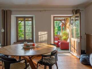 This charming dining area features a rustic wooden table with plush seating, perfect for intimate gatherings.