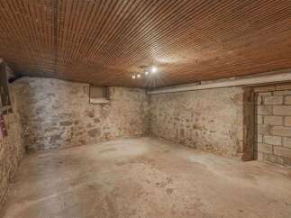 Explore the potential of this unfinished basement, featuring rustic stone walls and a durable concrete floor.
