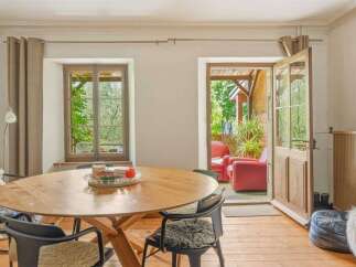 This charming dining area features a rustic wooden table surrounded by comfortable chairs, perfect for intimate gatherings.