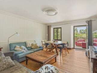 Experience comfortable living in this inviting open-plan space, featuring a cozy living area with plush seating and a rustic wooden coffee table.