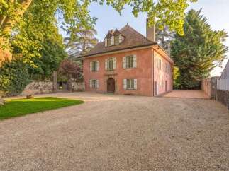 Discover this charming pink-hued residence, nestled amidst lush greenery and mature trees.