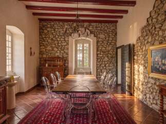 Experience rustic elegance in this charming dining room, featuring exposed stone walls and rich wooden beams.