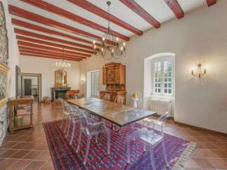 Experience elegant dining in this spacious room featuring a grand wooden table surrounded by clear chairs, perfect for hosting memorable gatherings.