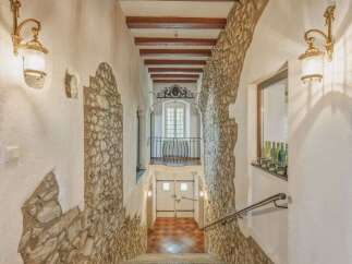 Step into a charming, rustic entryway featuring exposed stone walls and warm wooden beams overhead.