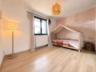 This charming children's bedroom features a whimsical house-shaped bed with a canopy, perfect for a cozy and imaginative sleep space.