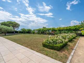 Discover this stunning property featuring a beautifully manicured lawn and vibrant rose bushes, perfect for outdoor enjoyment.