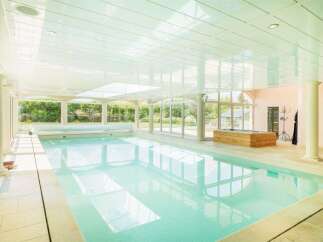 Indulge in luxury with this stunning indoor swimming pool, featuring a retractable cover for convenience and a bright, airy atmosphere.