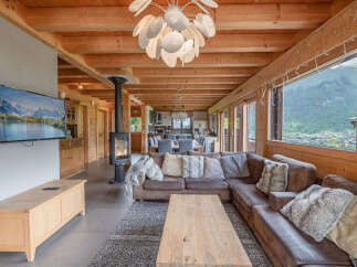 Experience luxurious mountain living in this stunning chalet, featuring a spacious open-plan living area with a modern fireplace and breathtaking panoramic views.