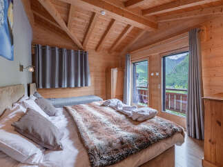 Experience ultimate comfort in this charming alpine bedroom, featuring a plush king-sized bed adorned with a luxurious faux fur throw.