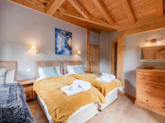 Experience cozy comfort in this charming bedroom featuring two inviting twin beds, perfect for guests or family.