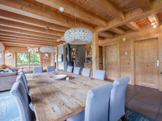 Experience rustic charm and modern comfort in this spacious dining area, featuring a large wooden table perfect for gatherings.