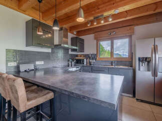 Experience modern mountain living in this stunning kitchen featuring sleek grey cabinetry and a spacious stone-look island perfect for casual dining or entertaining.