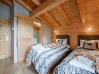 Experience cozy mountain living in this charming bedroom featuring two comfortable beds adorned with plush, faux-fur throws.