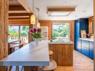 Experience rustic charm and modern luxury in this stunning kitchen, featuring exposed wooden beams and a sleek marble island.