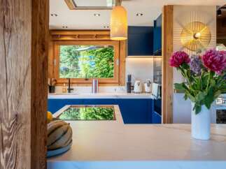 Experience modern mountain living in this stunning kitchen featuring sleek navy blue cabinetry and a marble countertop.