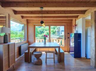 Experience rustic charm and modern comfort in this inviting dining area, featuring a solid wood table with benches, perfect for family gatherings.