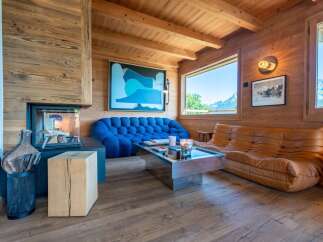 Experience luxurious mountain living in this stunning chalet, featuring a cozy fireplace and breathtaking panoramic views from large windows.