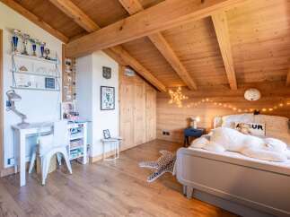Discover this charming attic bedroom, featuring a cozy bed adorned with playful pillows and a large polar bear plush.