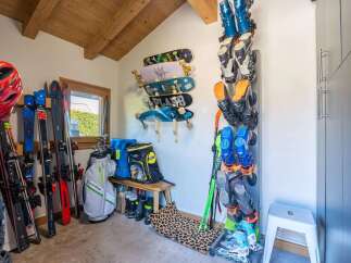 This spacious storage area is perfect for the outdoor enthusiast, featuring ample wall-mounted racks for skis, snowboards, and skateboards.