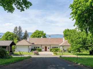 Nestled amidst lush greenery and mature trees, this charming property offers a serene retreat.