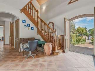 Step into this charming home featuring a beautiful wooden staircase and a bright, airy entryway.